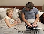 Couple with Laptop in Bed