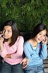 Two Girls Talking On Cell Phones