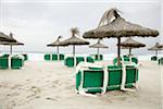 Tiki Umbrellas and Beach Chairs On Beach, Canyamel, Majorca, Spain