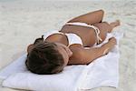 Young girl wearing bikini lying at the beach, Maldives