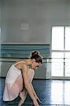 A female ballet dancer crouching on the toe-cap