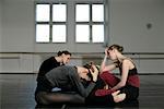 Exhausted female ballet dancers sitting on the floor