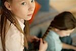 Girl plaiting friend's hair