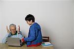 Grandfather and a boy using a laptop, fully_released