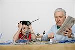 Grandfather and boy playing with a construction kit, fully_released