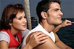 Couple sitting at sailboat border looking over the sea