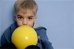 Little boy with yellow ball looking at camera