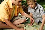 Father and son playing puzzle on a blanket