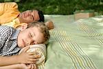 Father and son sleeping on a blanket