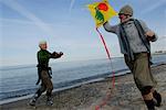 Zwei Reife Frauen fliegen einen Drachen am Ostsee-Strand