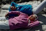 Two mature women lying side by side at Baltic Sea beach