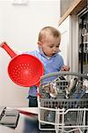 Baby boy emptying a dishwasher