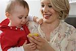 Mother handing son a lemon