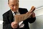 Asian businessman reading a newspaper