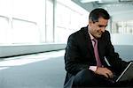 Businessman sitting on floor and using a laptop