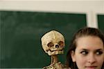 A teenage girl next to a skeleton