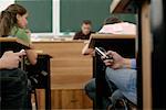 Pupils using mobile phones under their tables