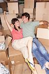 Couple assis parmi les boîtes de déménagement