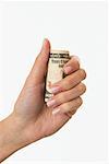 Woman's Hand Holding Roll of 100 Dollar Bills