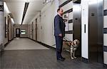 Blind Man With Guide Dog Waiting For Elevator