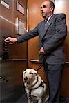 Blind Man With Guide Dog On Elevator