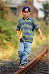 Boy With Skateboard Walking Along Train Tracks