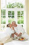Mature Couple Eating Breakfast In Bed