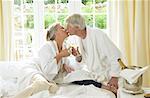 Mature Couple Drinking Champagne In Bed