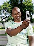 Man Sitting on Park Bench Taking Picture