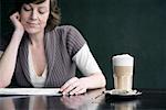 Woman Reading Newspaper at Cafe