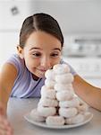 Little Girl Looking at Pile of Doughnuts