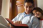 Father reading bible with daughter