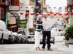 Couple Looking at Map in Street, Chinatown, Kearny Street, California, USA