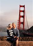 Couple assis par le Golden Gate Bridge, San Francisco, Californie, USA