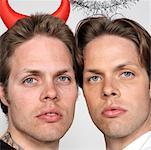 Portrait de deux frères jumeaux habillé comme le diable et l'ange