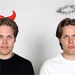 Portrait de deux frères jumeaux habillé comme le diable et l'ange