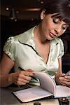 Woman Writing in Journal at Bar