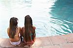 Two Girls Sitting by Swimming Pool