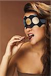 Woman With Blindfold Biting Chocolate