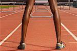 Back View of Woman Standing in Front of Hurdles on Track