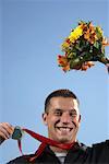 Man Holding Medal and Bouquet