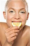 Woman Holding Lemon Slice to Face