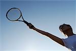 Vue d'angle faible d'une femme adulte mid tenant une raquette de tennis