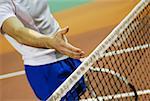 Close-up of a person's hand over a tennis net