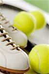 Close-up of a tennis shoe with tennis balls and a racket