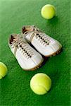 Close-up of a pair of tennis shoes with three tennis balls