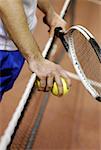 Milieu vue en coupe d'un homme tenant deux balles de tennis et d'une raquette de tennis