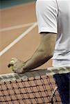 Mid vue en coupe d'un homme debout à côté d'un filet de tennis