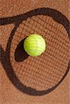 High angle view of a tennis ball on the shadow of a tennis racket