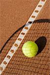 Ombre d'une raquette de tennis sur une balle de tennis